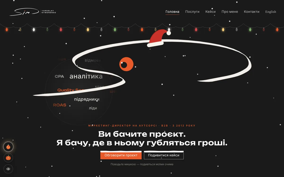 Так режим виглядає на symonenko.com: гірлянда, сніг і шапка Санти на банері з оком.