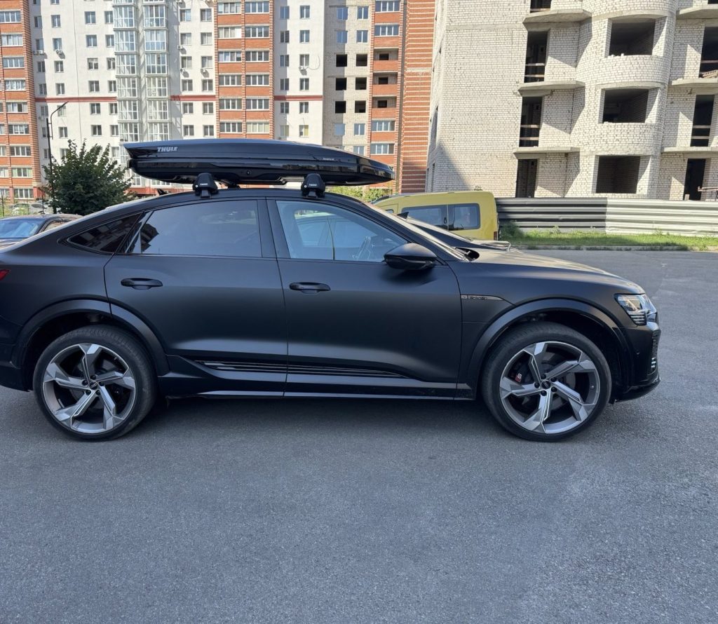 Чорний кросовер з боксом Thule на даху