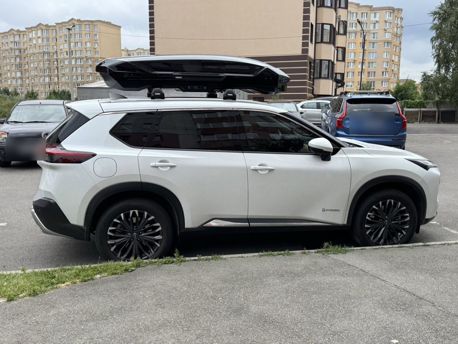 Білий Nissan з чорним боксом на даху